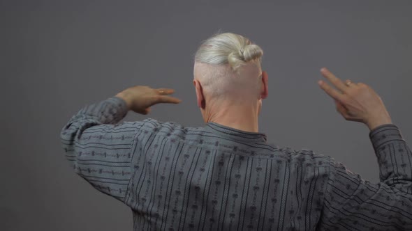 Pensioner Dances and Moves Holding Fingers in V-letter