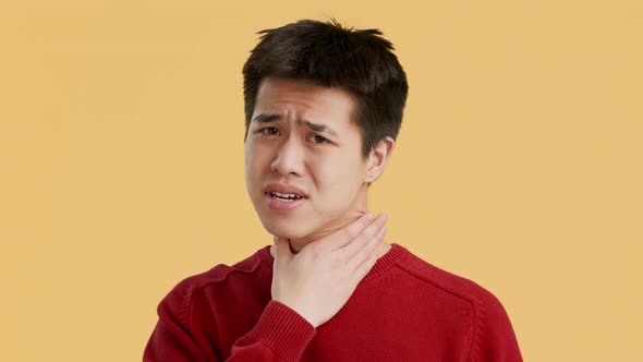 Sick Korean Guy Suffering From Sore Throat Over Orange Background
