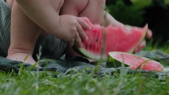 Baby Hands Holds Slice of Watermelon Outdoors