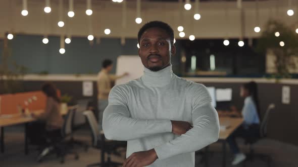 Young African American Handsome Businessman Looking at the Camera Standing in Modern Office with