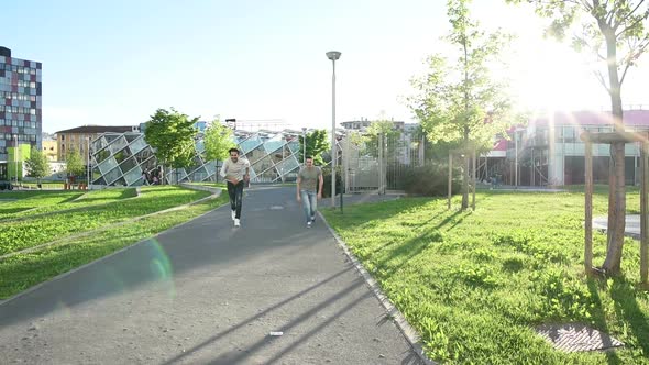 two young men outdoor jumping with arms raised