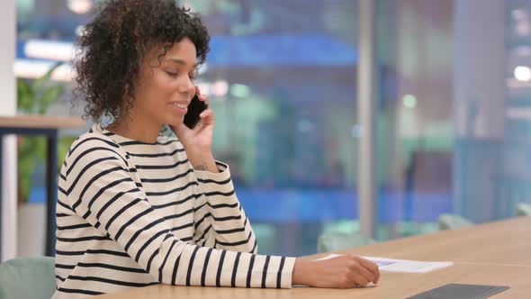 African Woman Talking on Smartphone in Office