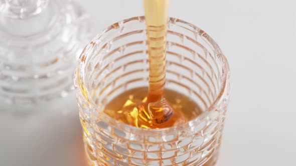 Pouring honey in a glass. Slow Motion. alt