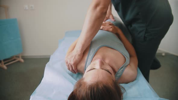 Woman Having an Osteopathic Treatment - Lying on the Couch While the Doctor Pushing on Her Body