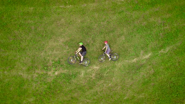 Aerial view of cyclists lying down on the grass with their bicycles in Slovenia.