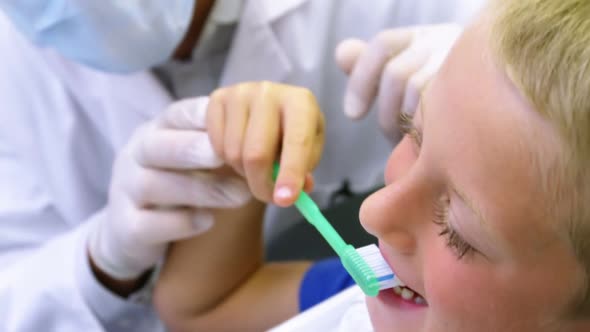 Dentist brushing a young patient's teeth