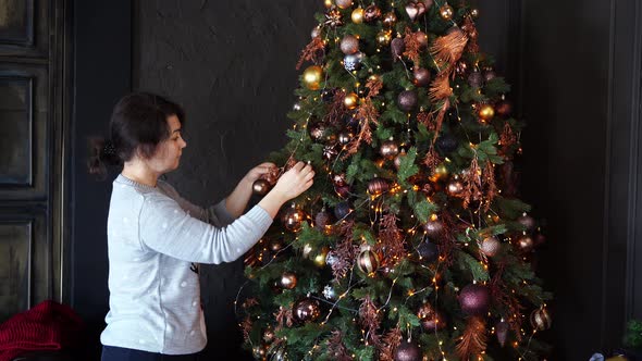 A Woman Dresses Up a Christmas Tree to Celebrate the New Year