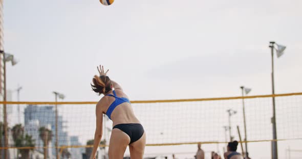 Slow motion of women playing beach volleyball during sunset