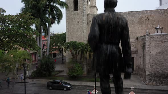 Aerial camera rising from behind a statue in Hidalgo Park continuing above the Rectory Jesus (third