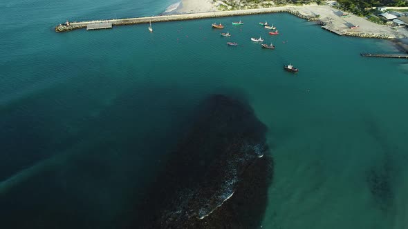 Aerial - Fly-over done over local fishing vessels anchored in small harbour of quaint fishing villag