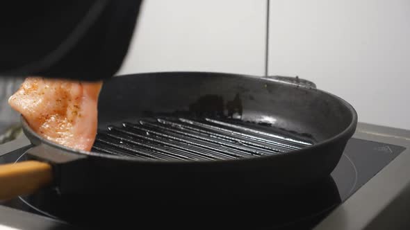 Male Hand of Cook Putting Chicken Fillet on Grill Pan at Cuisine Restaurant