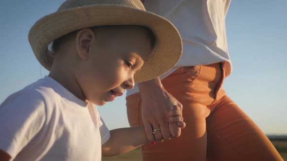 Mother and Little Son Holding Hands Into the Sunset. Child Have a Trust for Mother, Family Concept