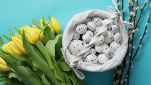 Holiday Contept Decoration with Easter Eggs and Yellow Tulips Over Blue