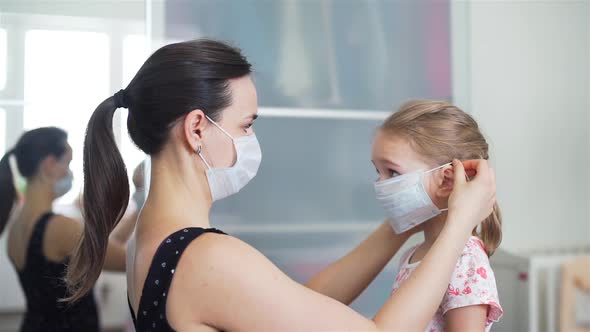 Woman Putting on a Medical Mask on Her Daughter