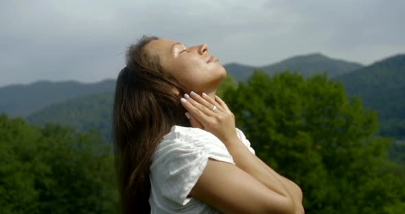 Girl Meditates Against Green Forestry Hills on Summer Day