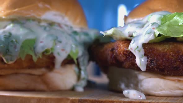 Close Shot of Two Homemade Fishcake Sliders with Dripping Sauce