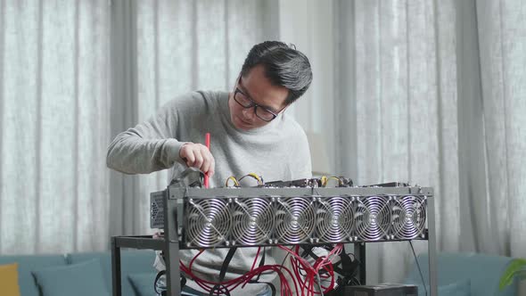 Asian Man Wearing Glasses Cleans The Mining Rig For Mining Cryptocurrency