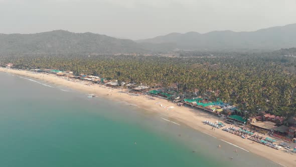 Paradisiac Palolem Beach, stretch of white sand on calm waters bay, Goa, South India