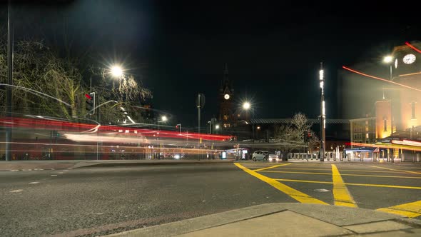 Traffic flying by Kings Cross Station at night. Time lapse of London City.