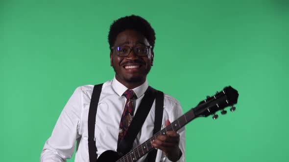 Portrait of Young African American Man Smiling and Playing Electric Guitar