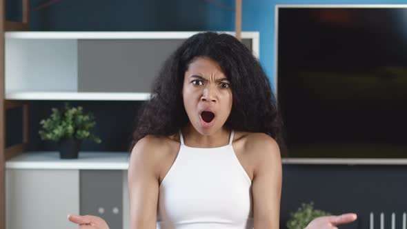 Shocked Frustrated African Mixed Race Young Woman Feel Stressed Look at Camera at Home Office