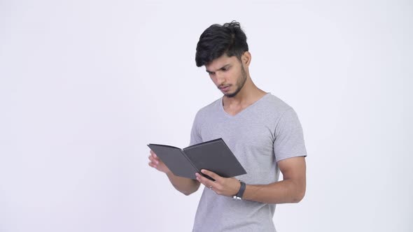 Young Happy Bearded Indian Man Reading Book