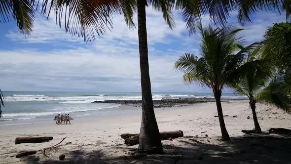 Group of Surfers Walking at The Santa Teresa Beach 