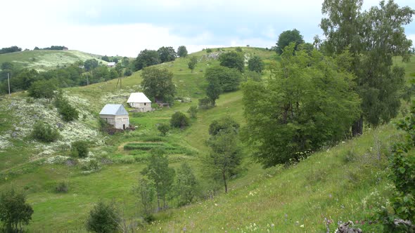 Buildings in the Mountains Among Trees and Bushes