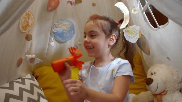 Little Girl Plays Space Aliens at Home Sitting in a Tent alt