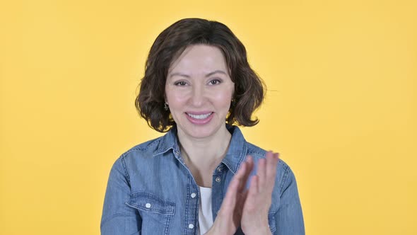 Cheering, Old Woman Clapping on Yellow Background 