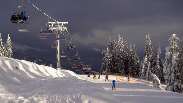 Ski Lift Carries Skiers and Snowboarders on the Mountain