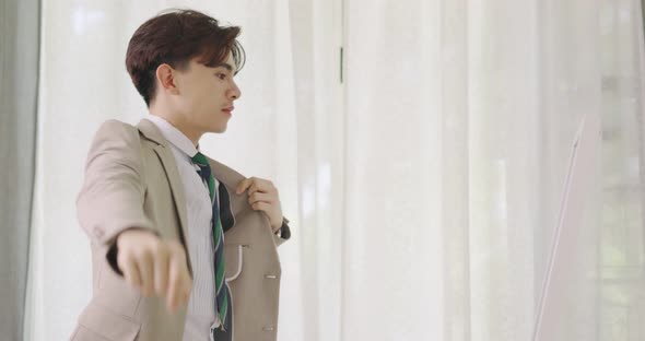 Handsome Man Puts Suit On During Morning Wedding Day. Young Groom Standing In Front Of The Mirror