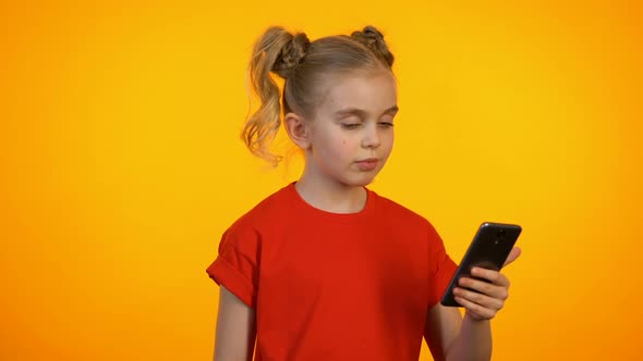 Cute Girl Showing Typing and Pointing at Phone, Winking and Showing Thumbs-Up