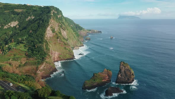 The Road Tucked Away Between Lush Green Cliffs and the Atlantic Ocean