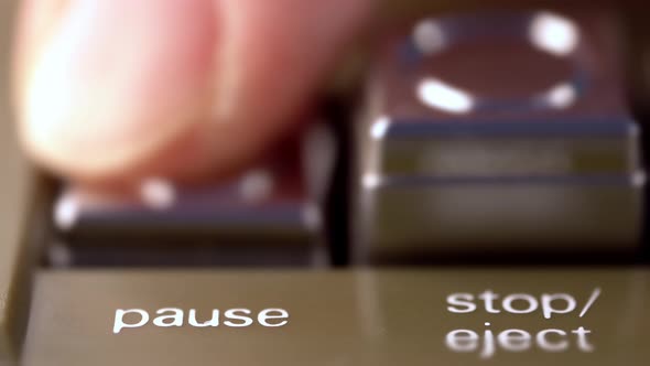 Pause Button of a Vintage Tape Recorder Pressed By a Finger Macro