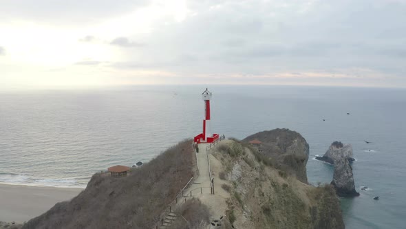 Aerial view of a red and white colored lighthouse with many vulture
