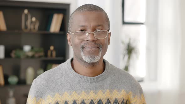 Close Up Portrait of Positive Senior African American Man Wearing Eyeglasses and Sweater Looking at