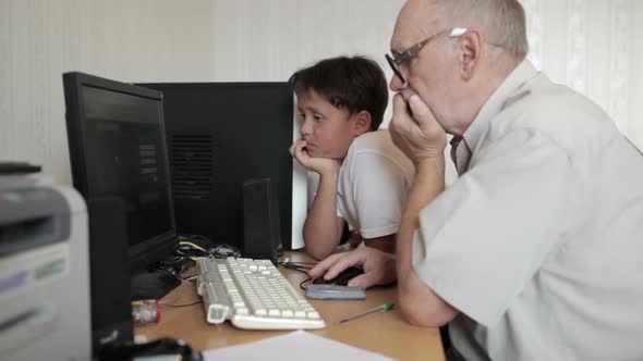 Grandfather repairs grandson computer 1