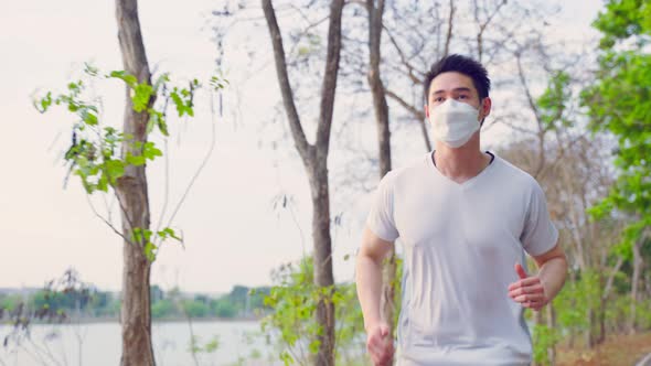 Asian young active sport male wear mask run on street in public park