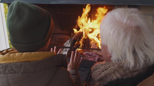 Child and Granddaddy Warming Hands by Fire and Chatting