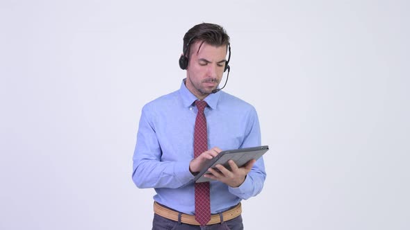 Young Hispanic Businessman As Call Center Representative Working with Digital Tablet
