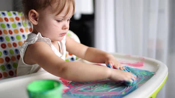 Cute Little Girl Painting with Fingers at Home