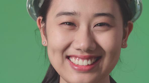 Close Up Of Asian Female Engineer With Safety Helmet Smiling In The Green Screen Studio