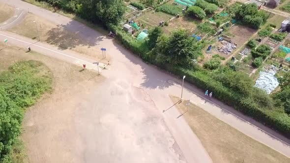 People walking along rural farm plots in Exeter, England, AERIAL