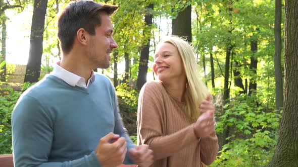 A Young Attractive Couple Dances on a Bench in a Park on a Sunny Day, Closeup