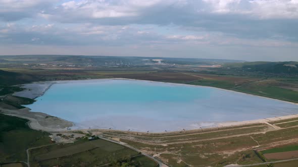 Aerial view of a reservoir full of blue toxic sludge