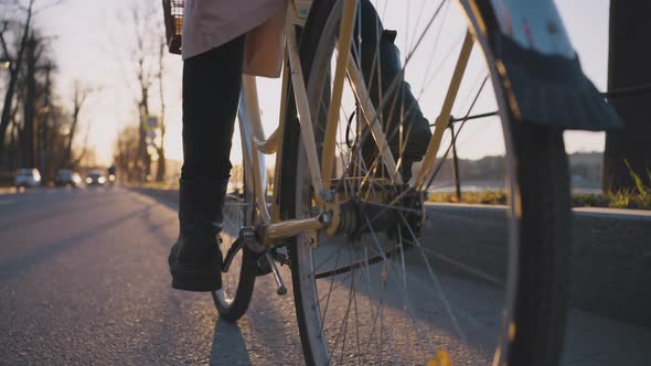 Woman Rides a Bike in the Evening on the Road at Sunset Pedals Closeup