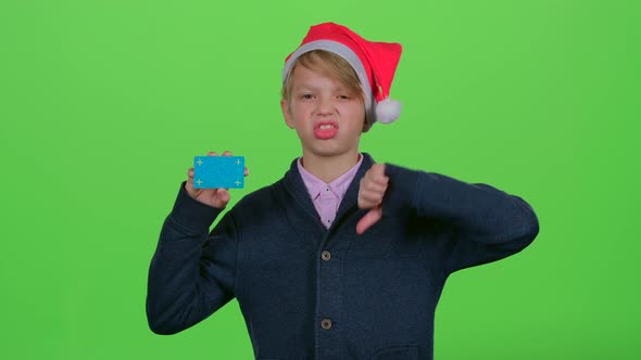 Teenager in the New Year Hat with a Credit Card Shows Dislike and Then Like on a Green Screen