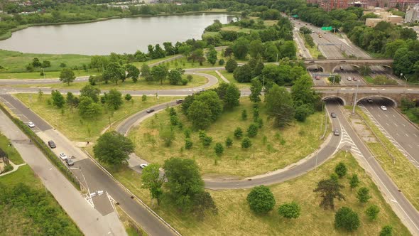 An aerial view over a parkway exit on a cloudy day. The drone orbits the circular exit in aclockwise