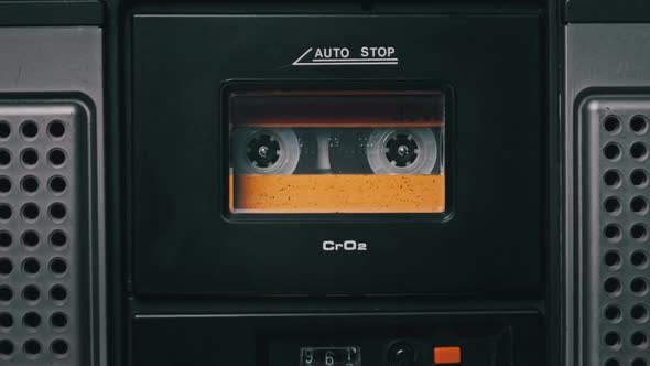 Vintage Yellow Audio Cassette Playing in Deck of an Old Tape Recorder